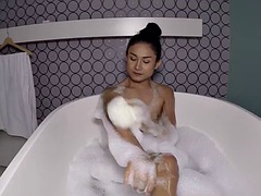 Petite Asian ladyboy Nonny takes a soapy bath before anal doggy style