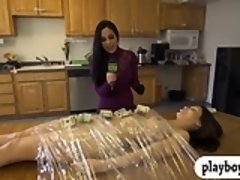 Big boobs brunette wrapped with plastic foil on a table